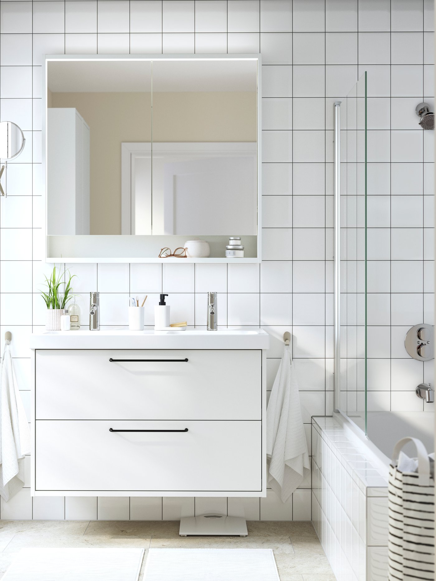 A very white bathroom with white tiles and white hanging HAVBÄCK cabinets
