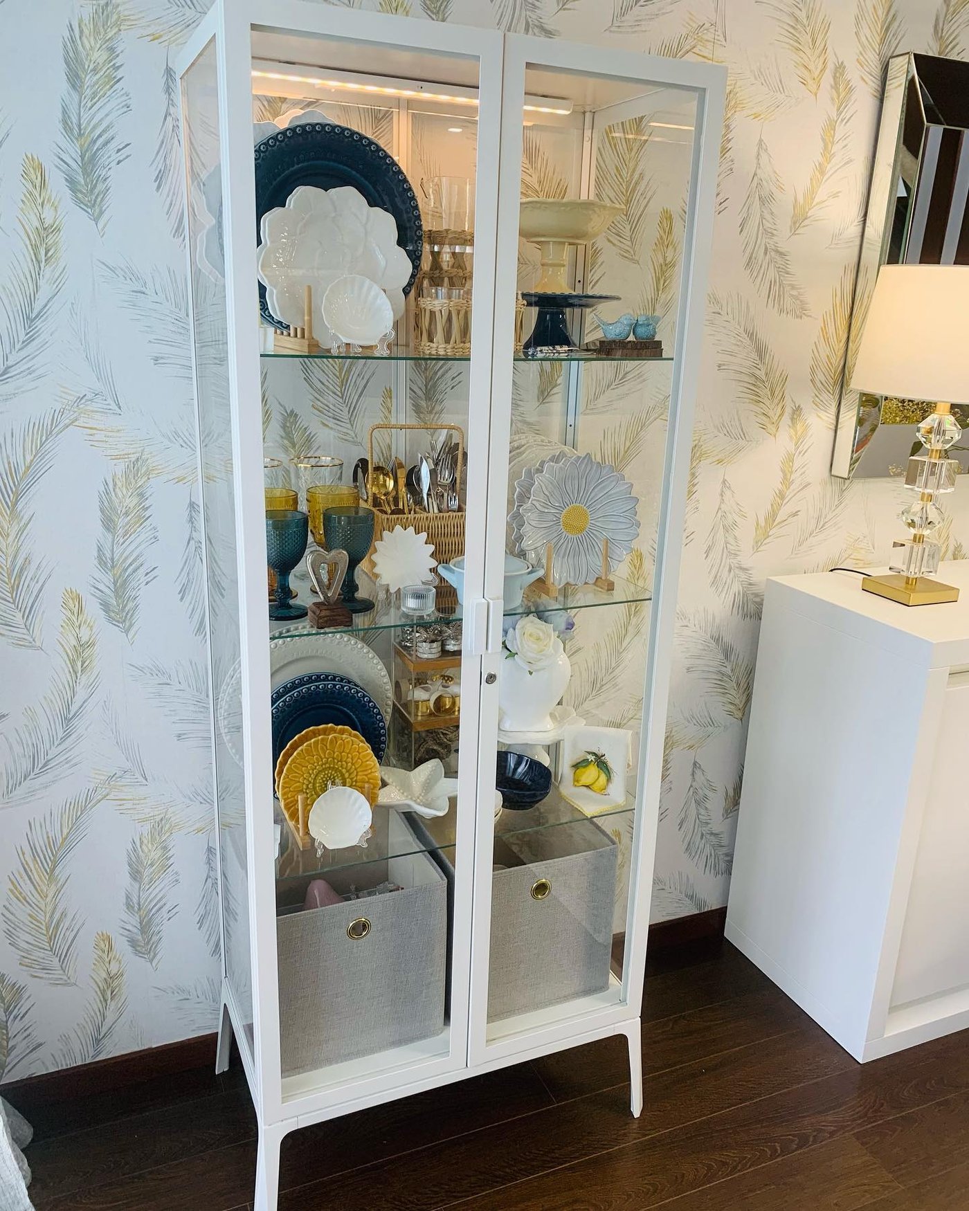 Un armario blanco con puerta de cristal MILSBO