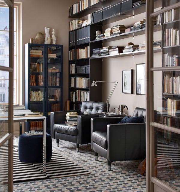 A dark blue BILLY bookcase with glass-doors in the living room
