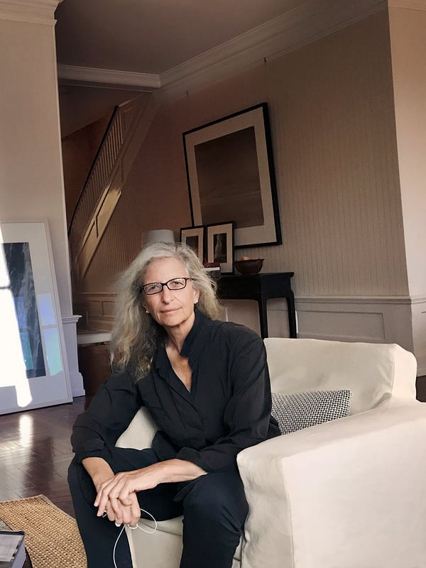 Annie sits in an armchair, being photographed.
