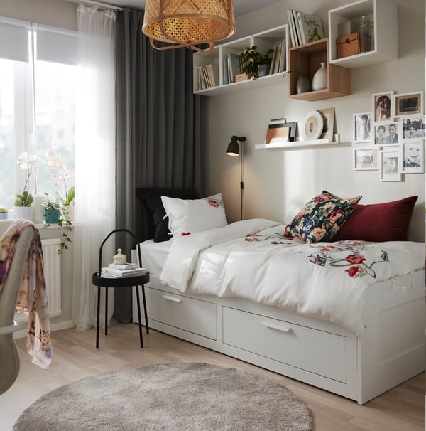A white/floral patterned JÄTTELILJA duvet cover and pillowcase in the bedroom
