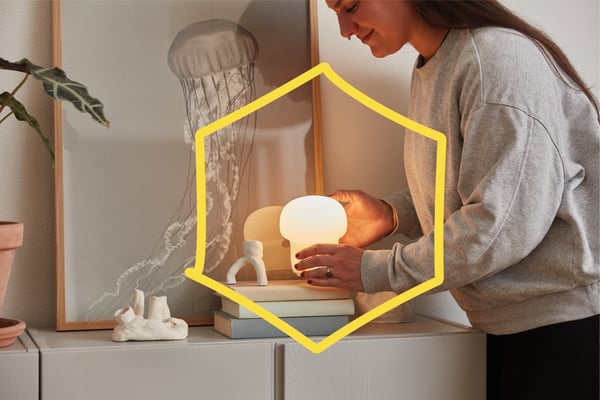 Women putting lamp on shelf