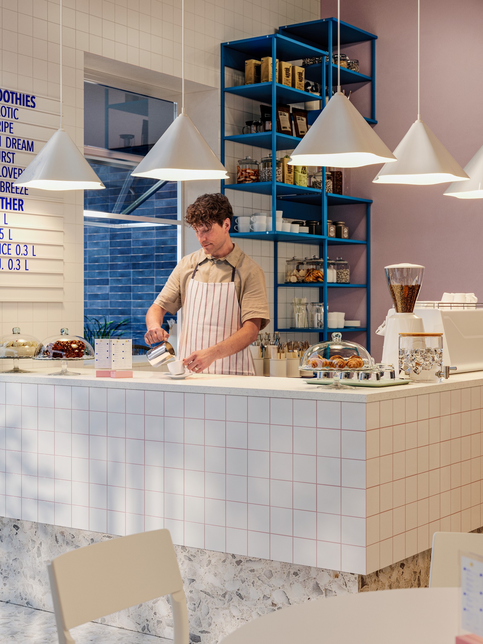 A barista is pouring coffee under white plastic ZEBRASÄV pendant lamps at a café bar next to serveware and croissants.