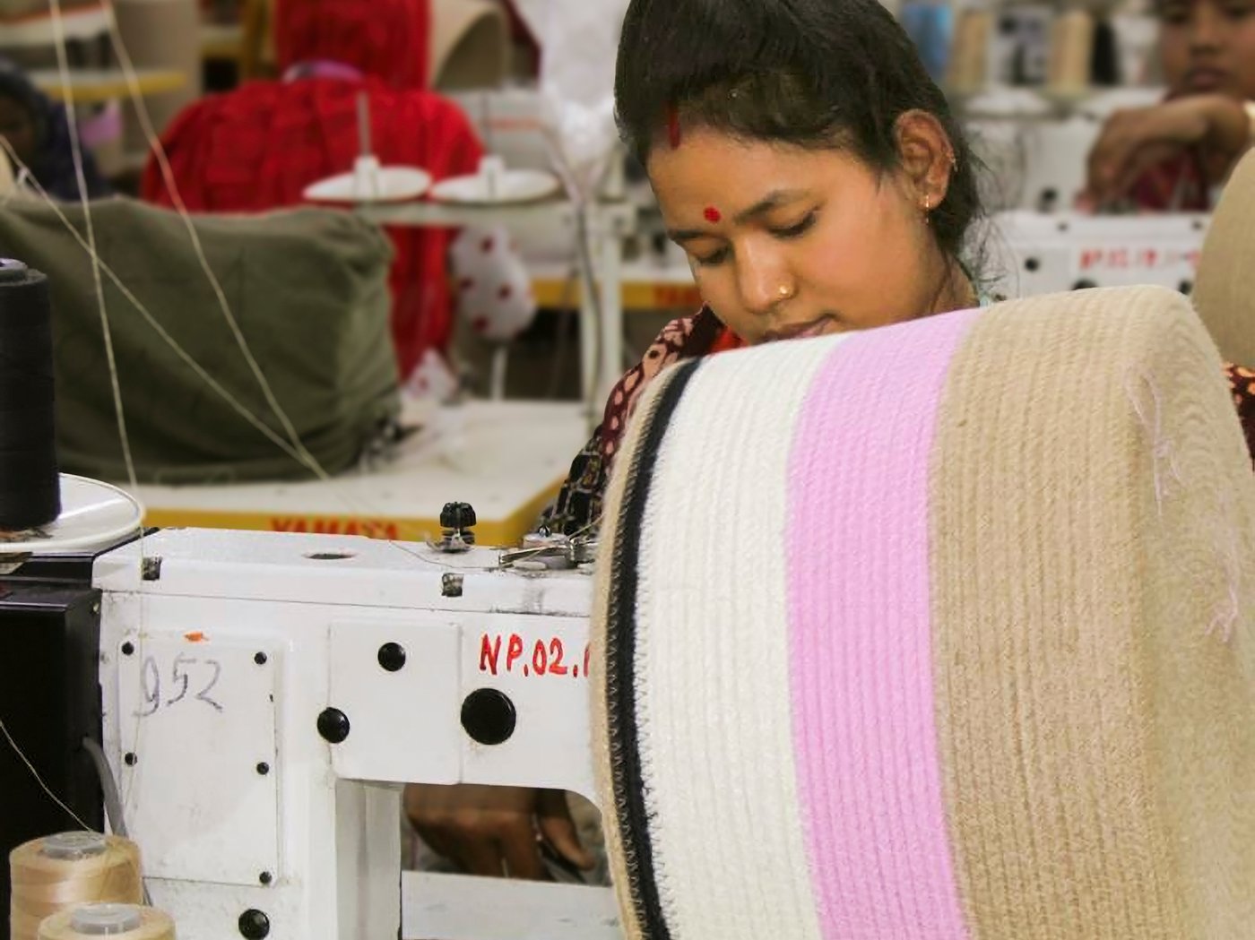 Person working on a basket in front of a sewing machine.