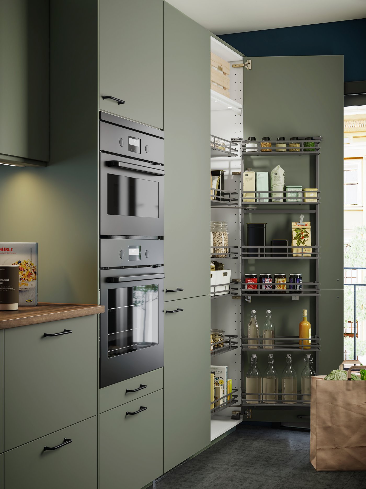 Eine METOD Küche mit grünen Fronten und 2 Backöfen übereinander. Daneben ein Schrank mit Apothekerauszug.