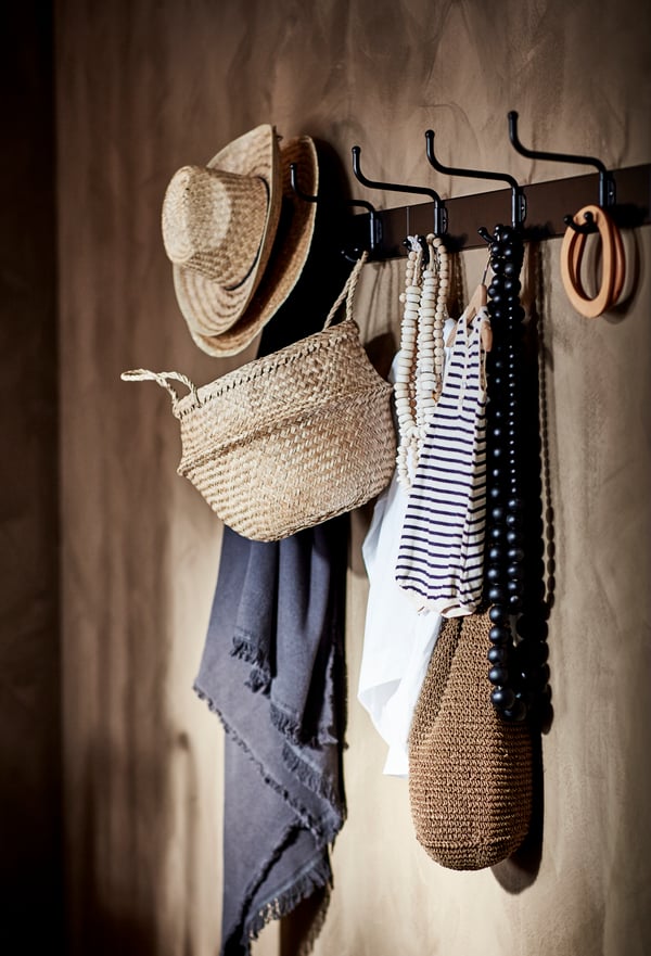 A black PINNIG rack with 3 hooks in the hallway