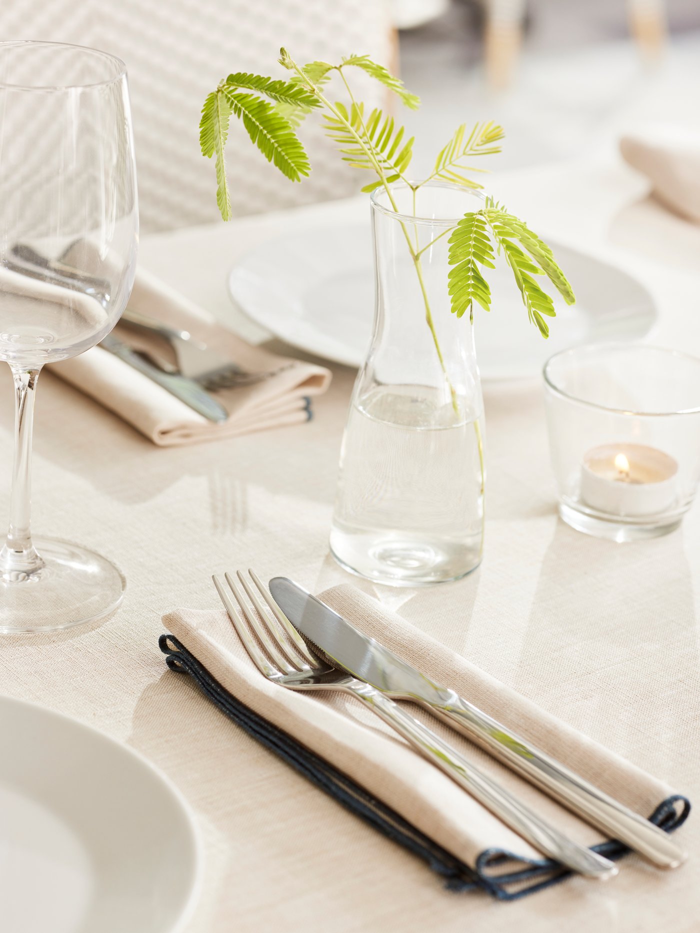 Gedekte tafel met daarop een glazen vaas.