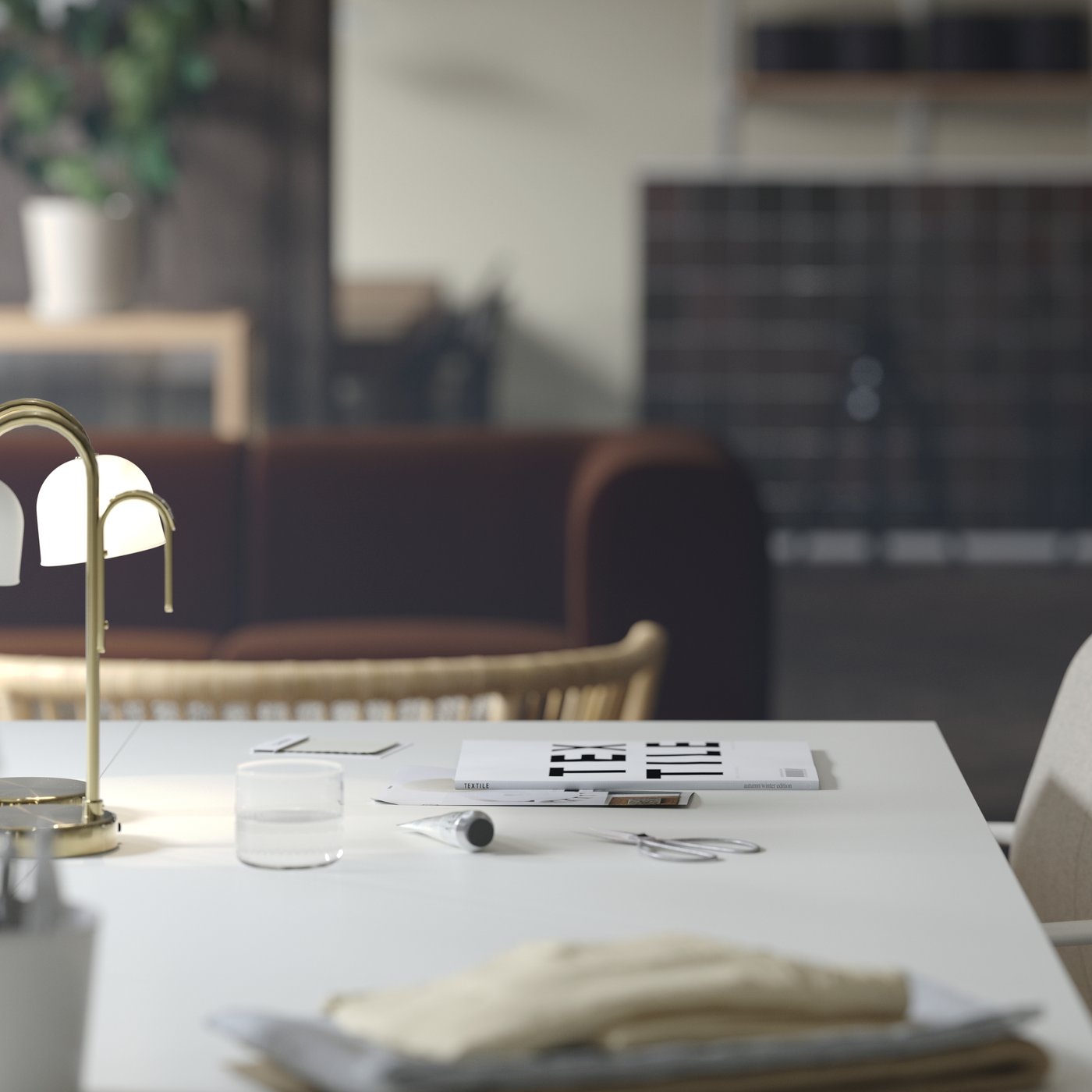 Lähikuva TROTTEN-työpöydästä, jonka päällä on siirreltävä TVÅMASTAD-led-valaisin. Taustalla näkyy tummanruskea sohva.