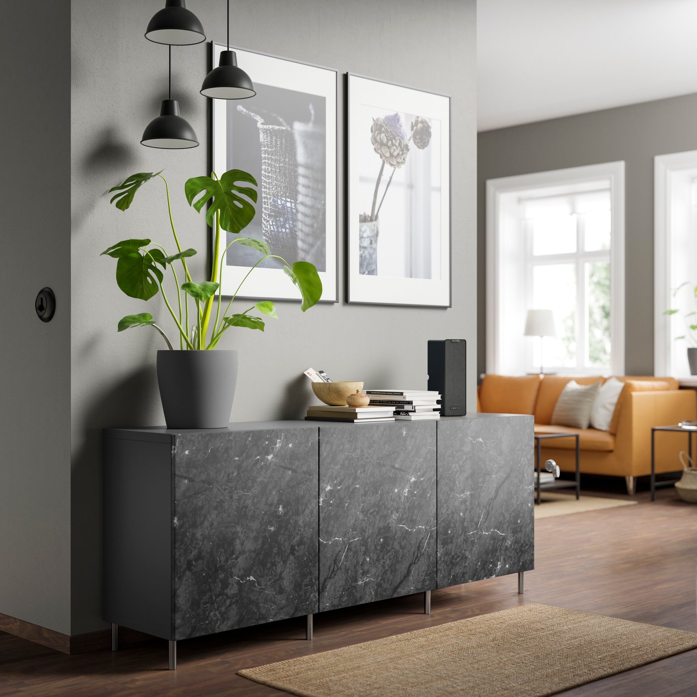 BESTA storage sideboard cabinet in living room area, with dark grey frames and marbled doors. A low pile rug covers the floor infront of the storage cabinet. 