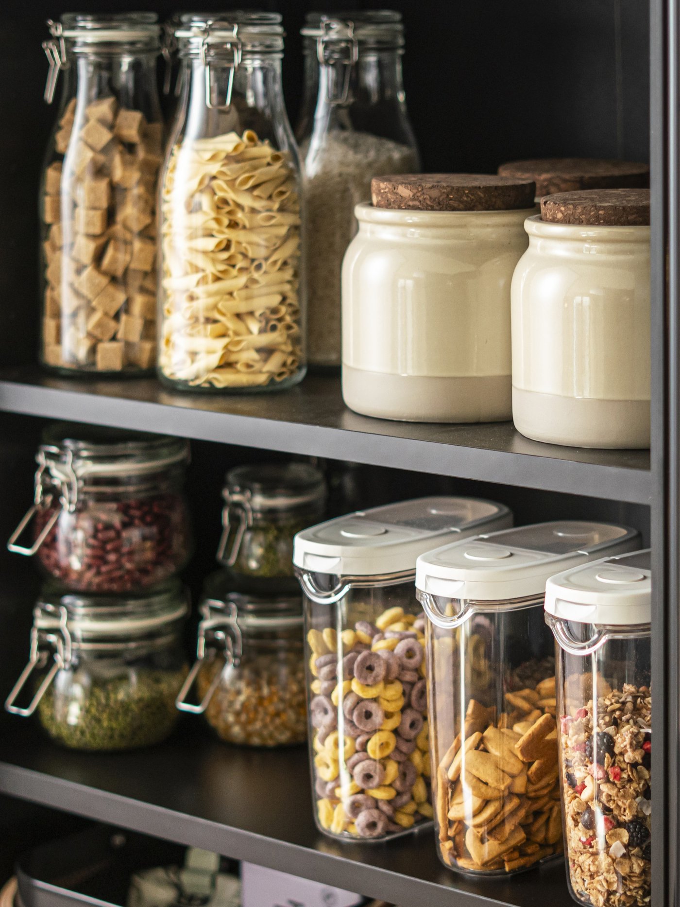 Barattolo KORKEN in vetro trasparente con tappo, posizionato su uno scaffale insieme ad altri barattoli riempiti con ingredienti secchi.