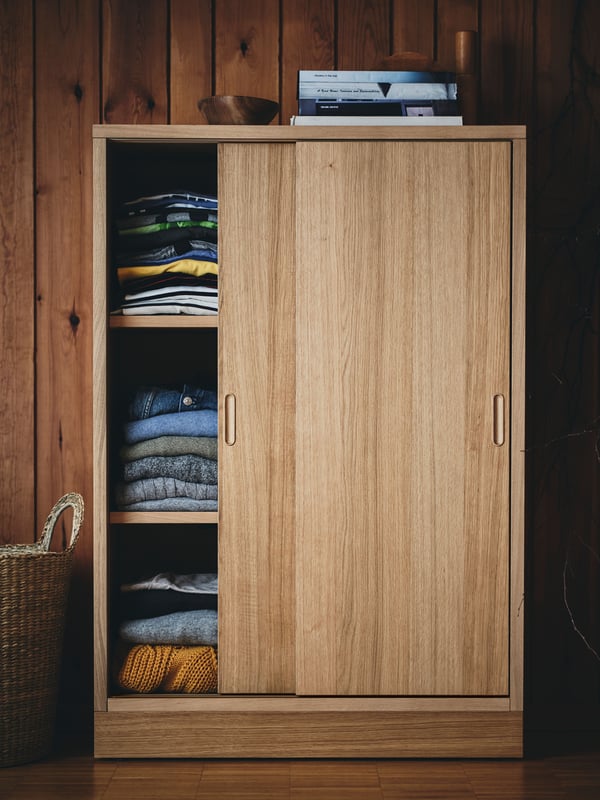 An oak veneer TONSTAD cabinet with sliding doors