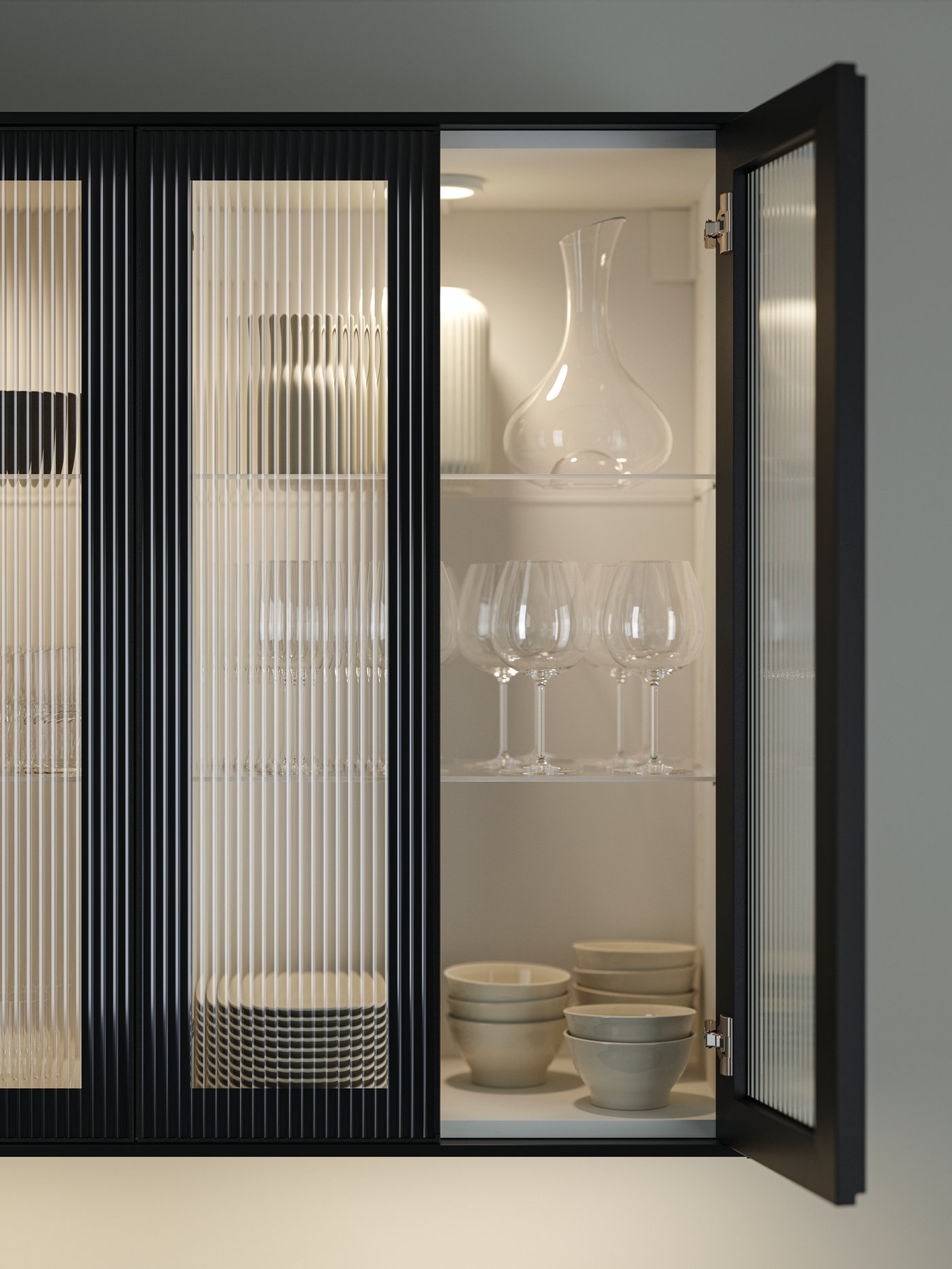 An upper kitchen unit with glass doors lit up with integrated lighting and glasses inside