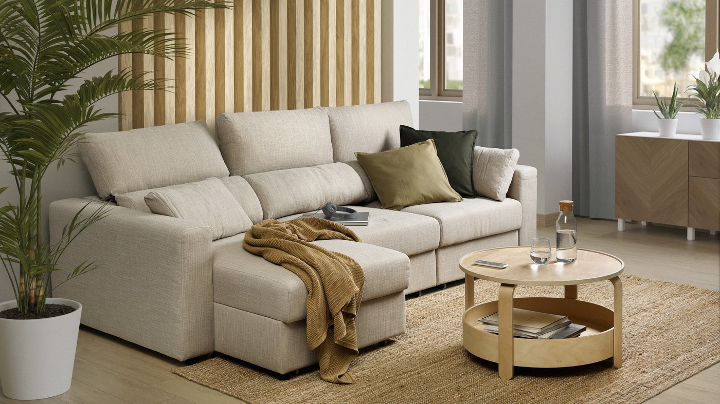 Soggiorno moderno con grande divano angolare beige, decorato con cuscini e plaid, tavolino rotondo in legno e piante in vaso su tappeto in fibra naturale.