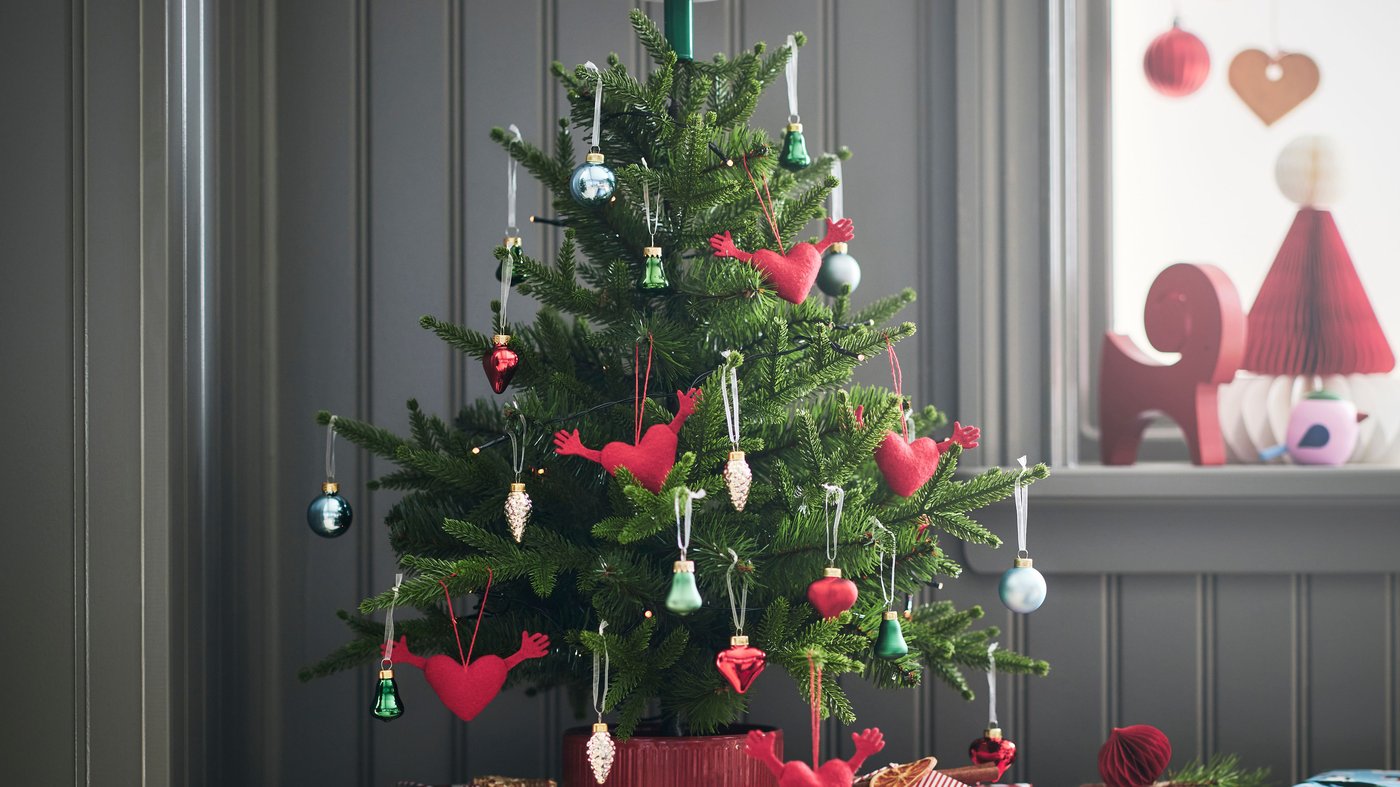 Minikuusi on koristeltu VINTERFINT-kuusenkoristeilla. Kuusen juurella joululahjoja.