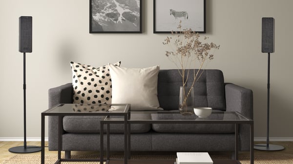 Two SYMFONISK WiFi speaker units placed on each side of a sofa to create a stereo pair.
