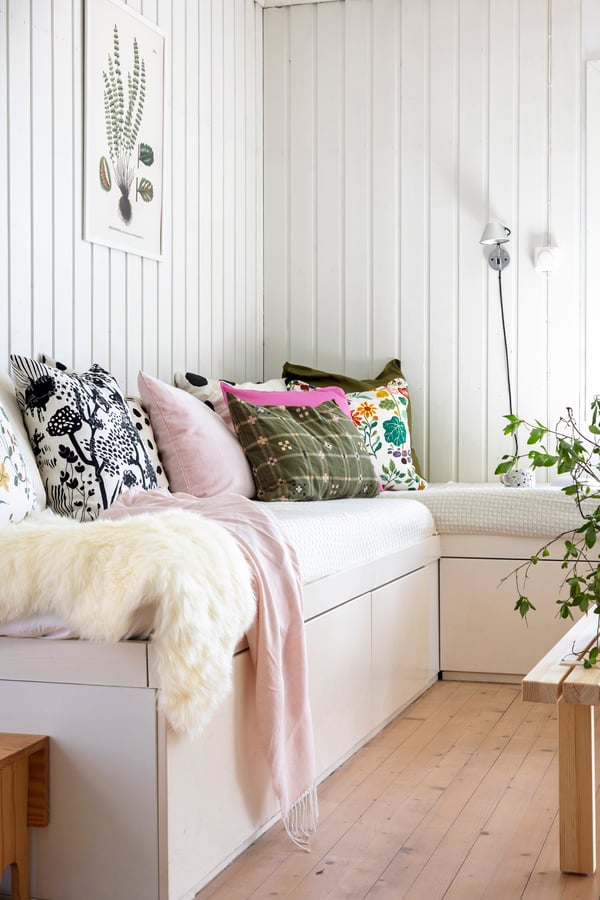 Sofa i stua med puter i ulike farger og mønstre. 