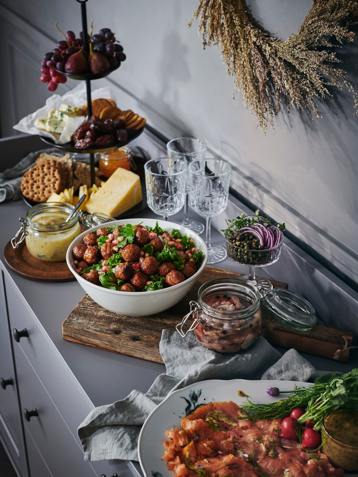 Des plats de service, des bocaux et des bols contenant différents aliments disposés sur un buffet HAUGA où les gens pourront se servir.