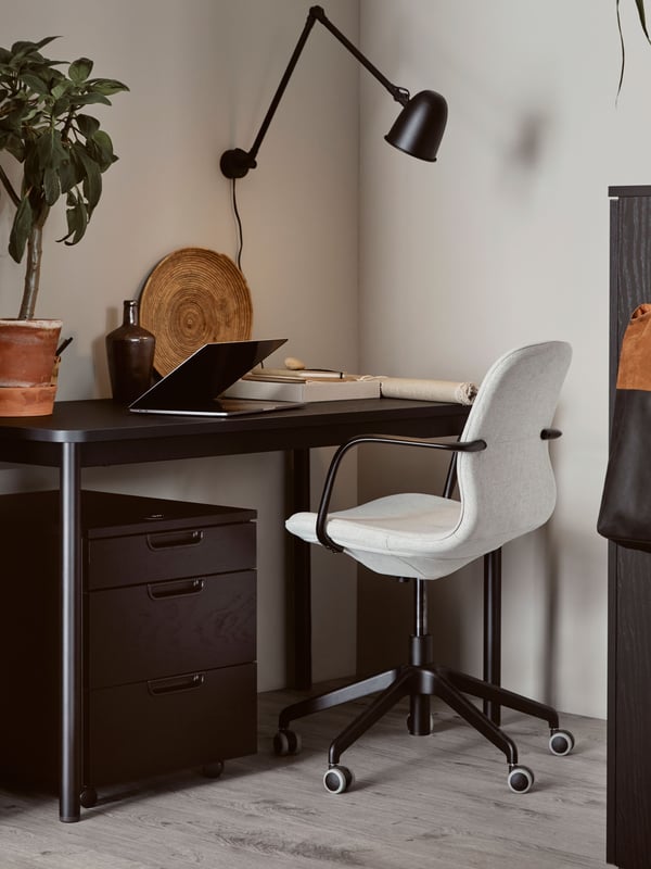 Cajonera negra GALANT junto a silla LÅNGFJÄLL.