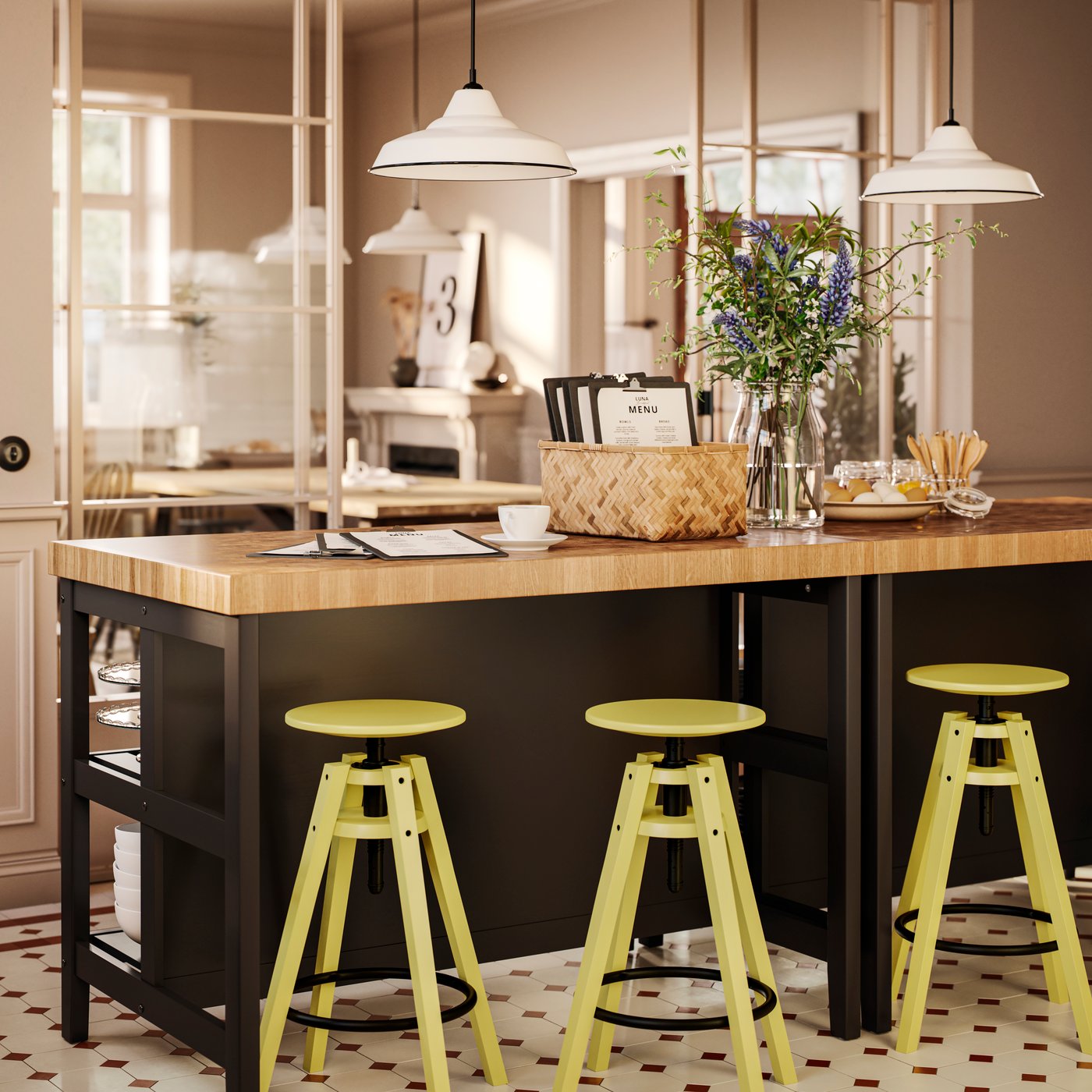 Two VADHOLMA kitchen islands with oak veneer worktops and black bases with various items as a buffet area is being set up.
