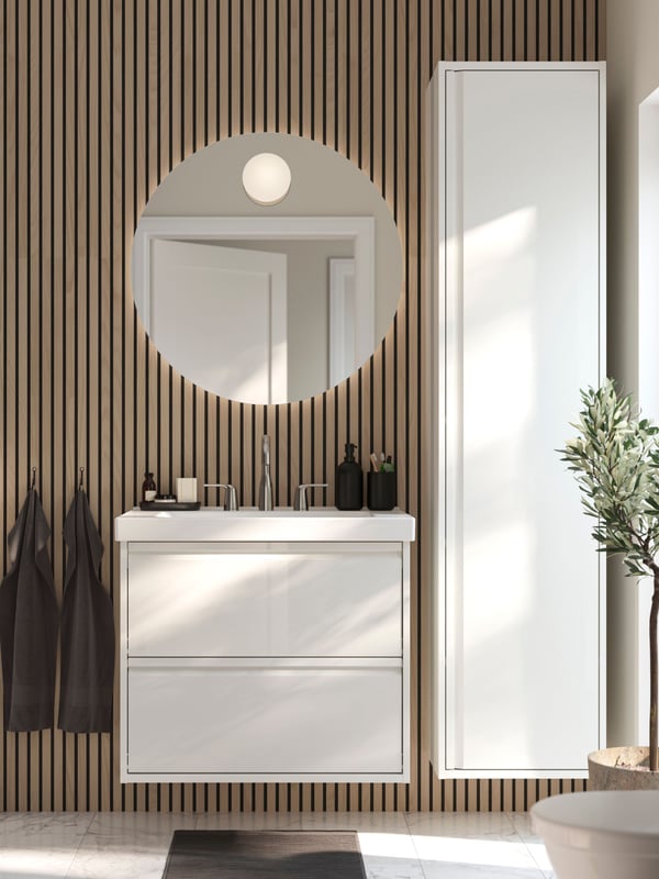 A high-gloss white ÄNGSJÖN high cabinet with door