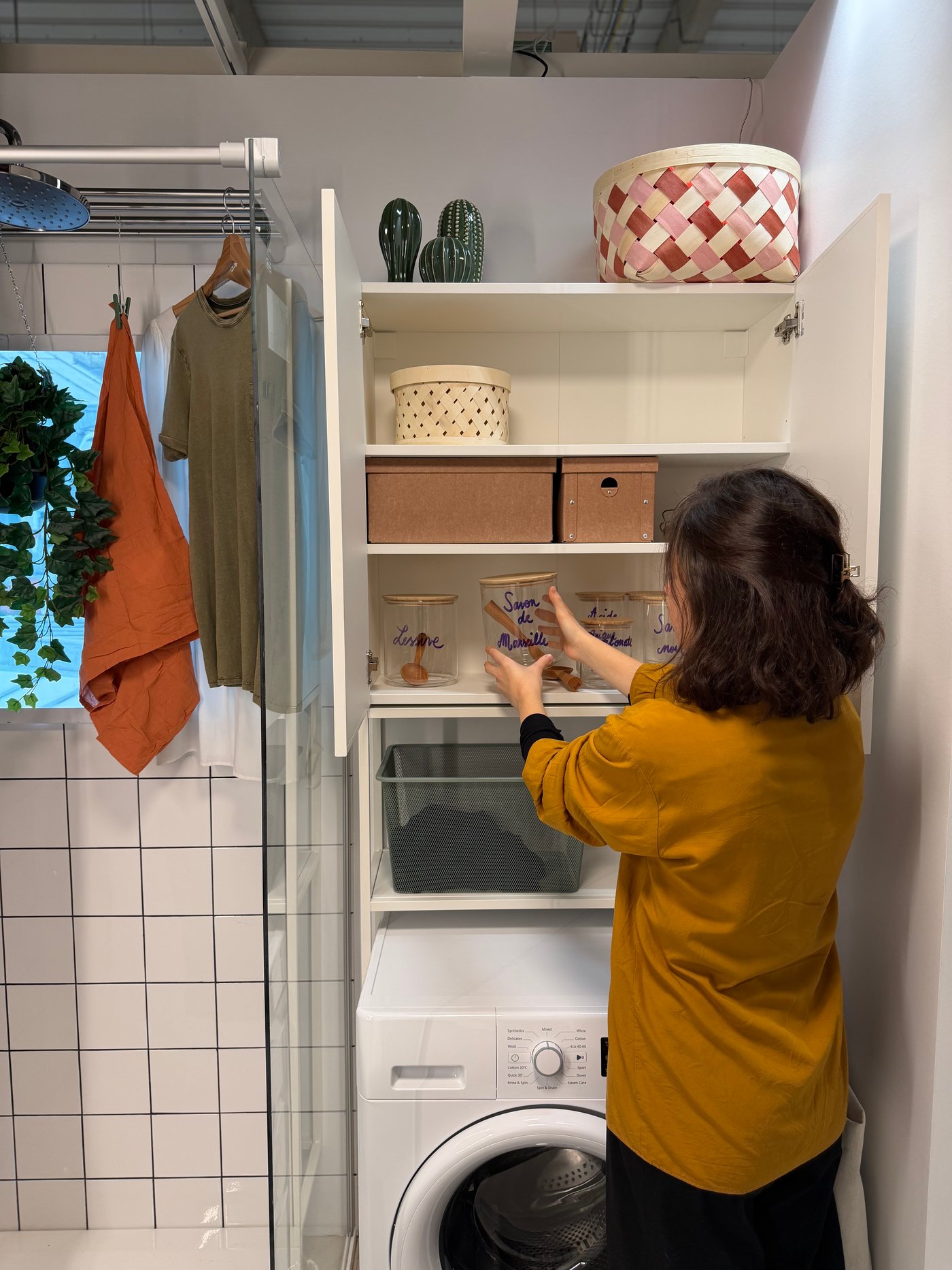 Une femme touchant des bocaux dans sa salle de bain