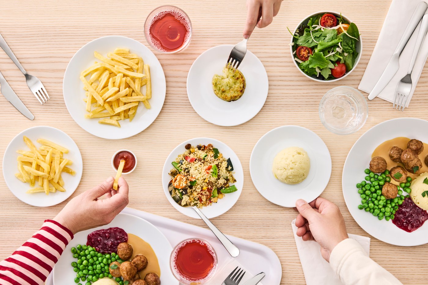 Klasická jídla z IKEA restaurace na stole z březové dýhy. 