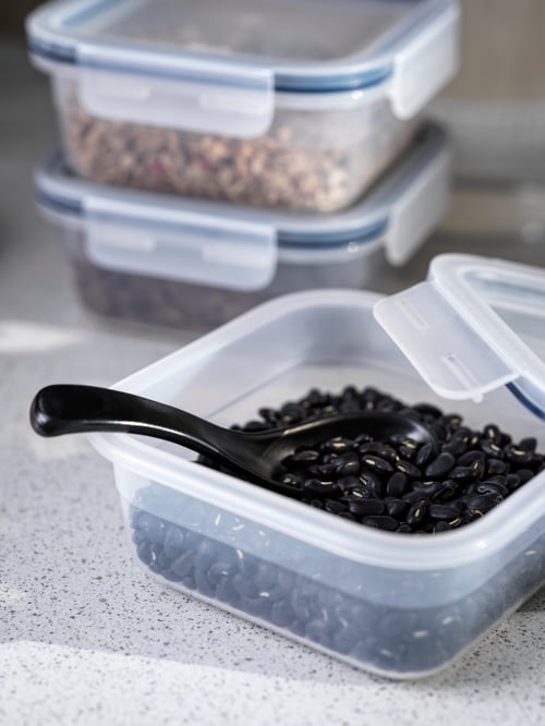 ふたを開けたプラスチック製のIKEA 365+ 保存容器に、乾燥黒豆とスプーンが入っている。そばに保存容器がもう2個重ねて置いてある。