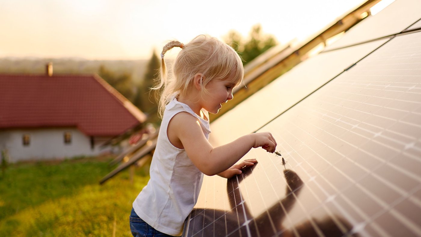 Una bambina tocca un pannello solare
