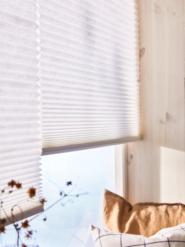 Pleated & cellular blinds in a window with a lot of sun shining through