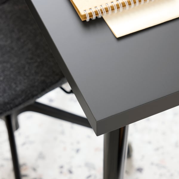 A close-up of LINNMON tabletop and LÅNGFJÄLL conference chair in dark grey/black.