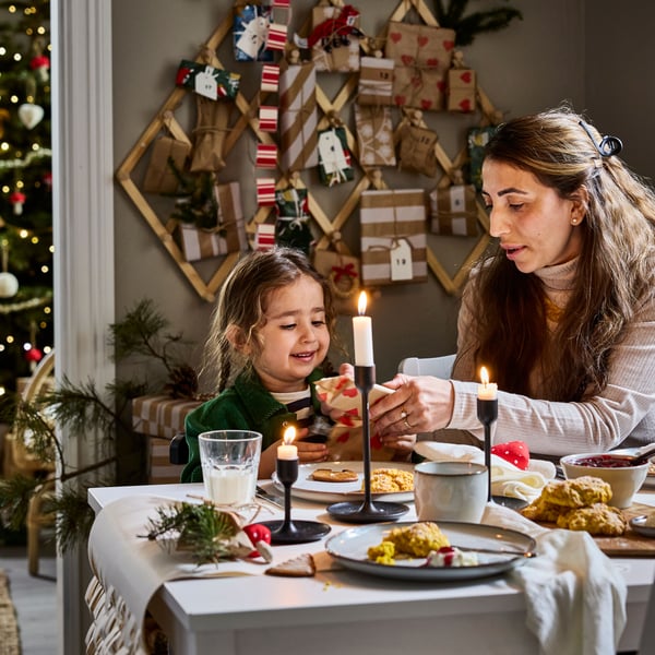An adult and a child are having dinner at a dining table 