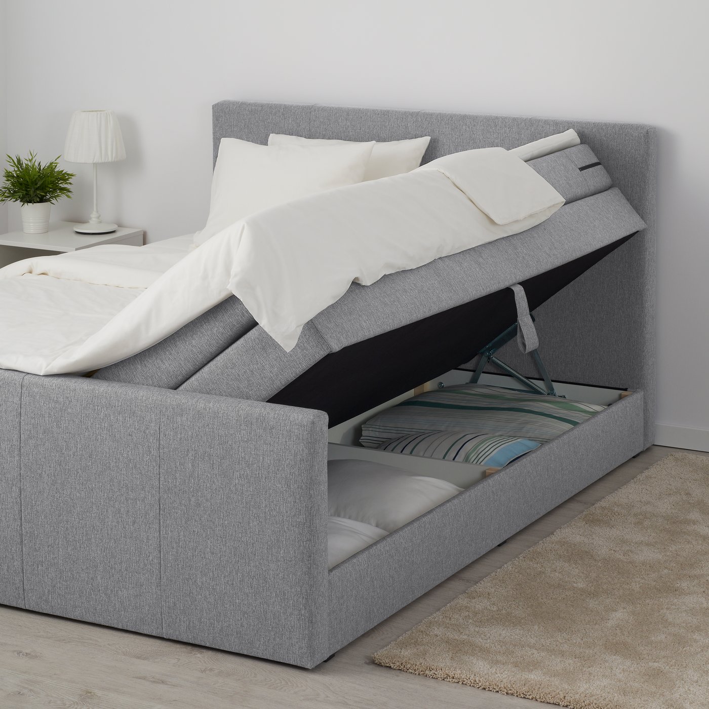 Graues Boxspringbett mit praktischer Aufbewahrung