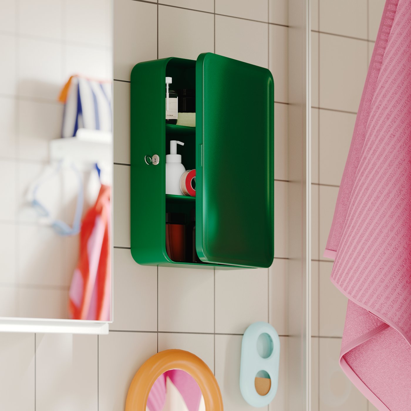 Ett grönt HUSBYÅN väggskåp med öppen dörr, väggmonterat i ett kaklat badrum, hyllor med toalettartiklar och en rosa handduk.