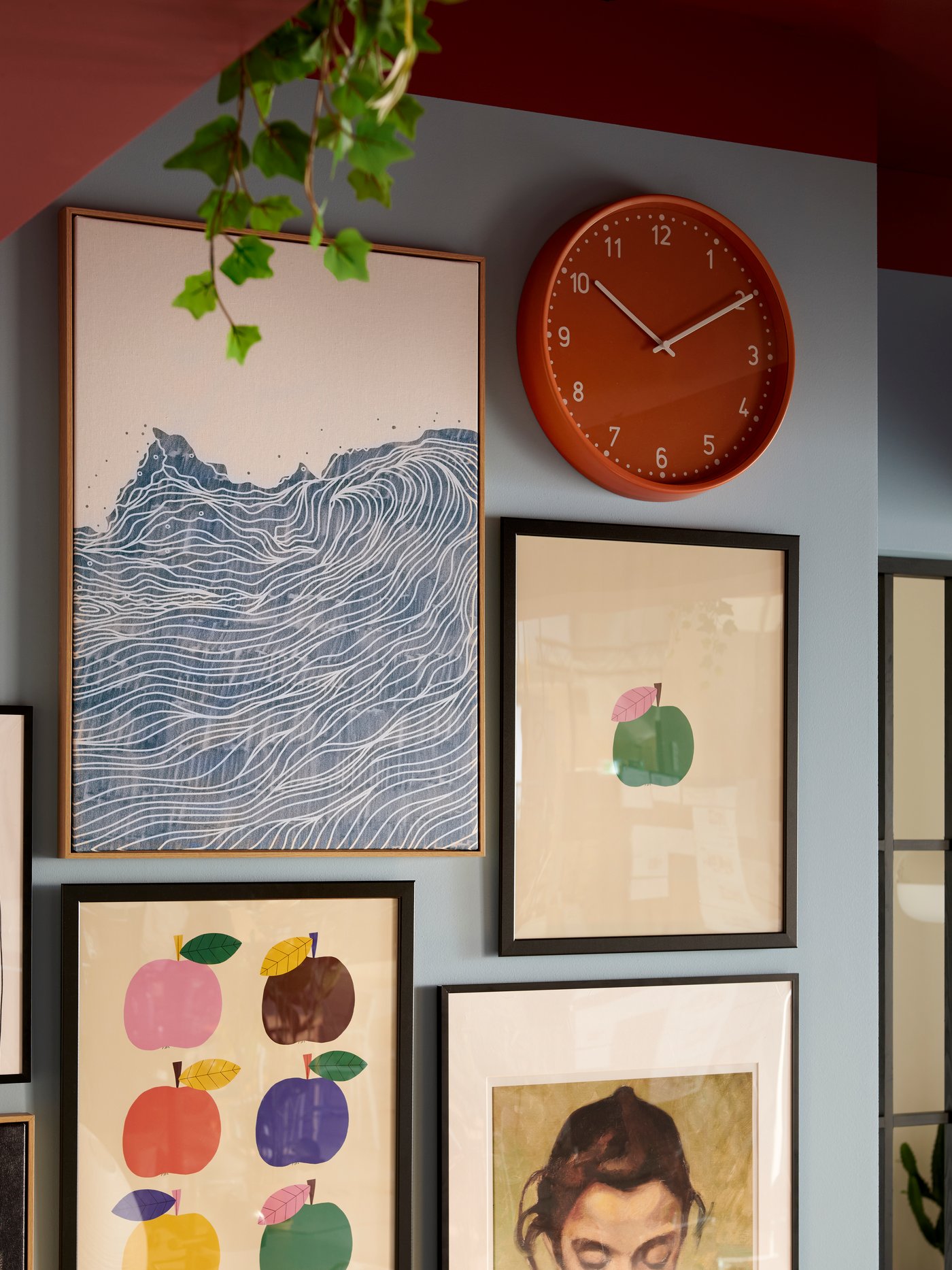 Kolore biziko gela batean, markoztatutako artelan ugari eta BONDIS erloju laranja bat duen hormako sekzio bat ageri da.