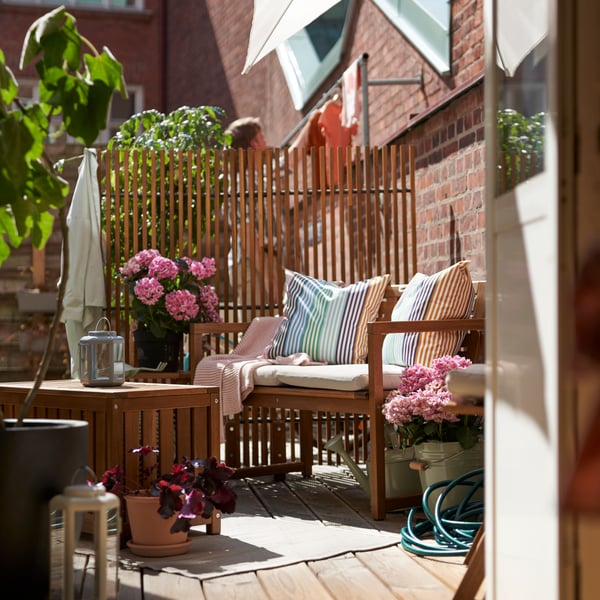 Banco exterior NÄMMARÖ con respaldo, pensado para jardines, terrazas o espacios al aire libre.