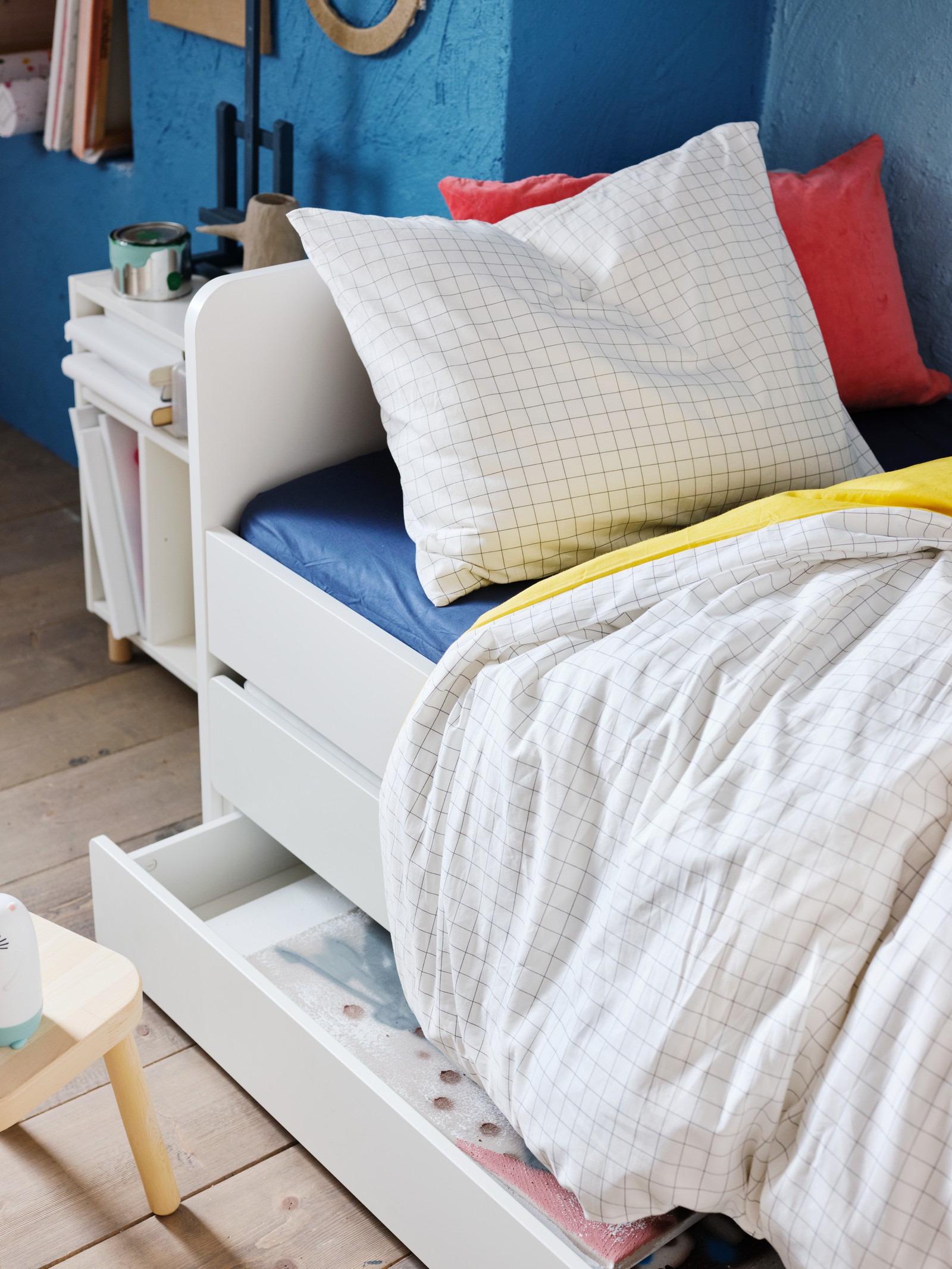 В детской спальне стоит кровать, застеленная пододеяльником и наволочкой ВЭНКРЕТС с желто-белым узором в клетку.