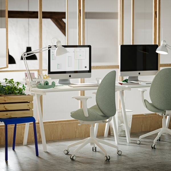 A small office with two white TROTTEN desks, light green/white HATTEFJÄLL conference chairs and white TERTIAL work lamps.