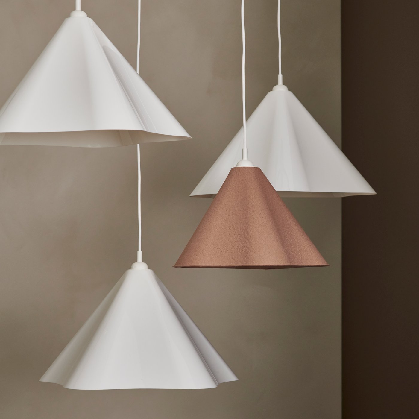 Nahaufnahme von vier ZEBRASÄV Hängeleuchten, die von einer Decke hängen. Drei davon sind weiß, die vierte beige.