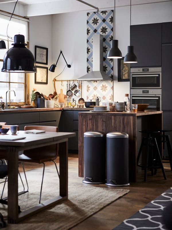 A METOD kitchen with a kitchen tile backsplash, wooden kitchen island and two MJÖSA pedal bins.