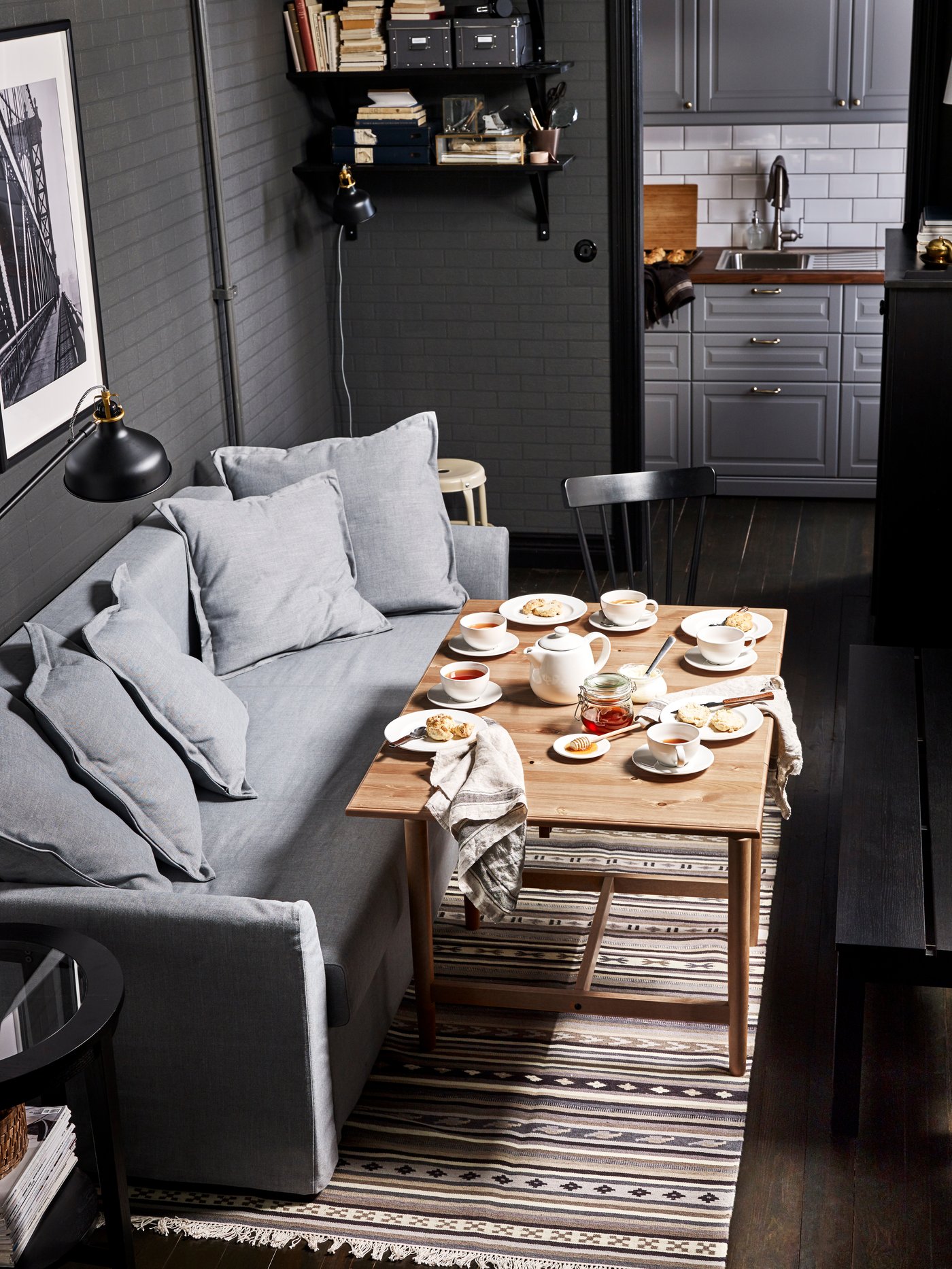 Ein graues HOMLSUND Sofa in einem Wohnzimmer mit Couchtisch