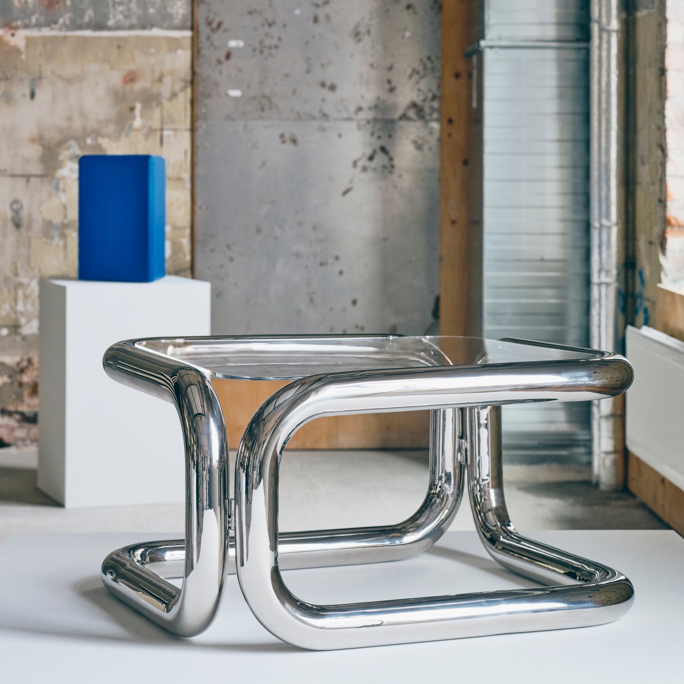 Close up of a shiny coffee table with a frame made from metallic pipes.