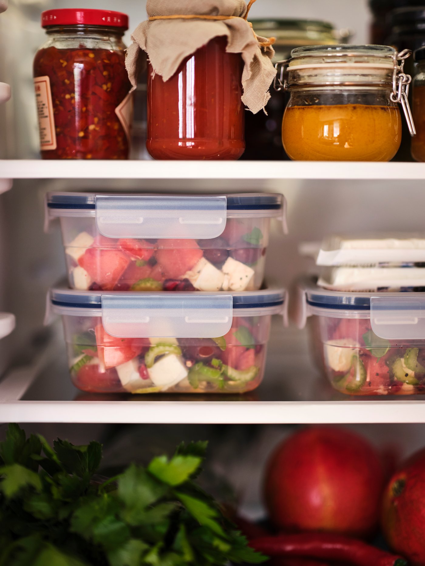 IKEA 365+ food containers filled with fruits and salad is placed in the refrigerator.