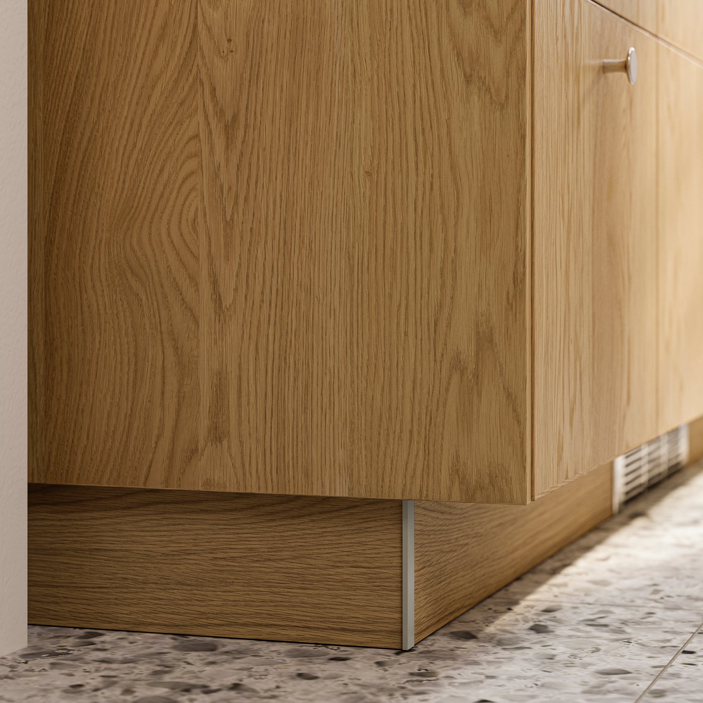 A closeup of a SEKTION cabinet with a cover panel and a plinth in SINARP oak veneer.