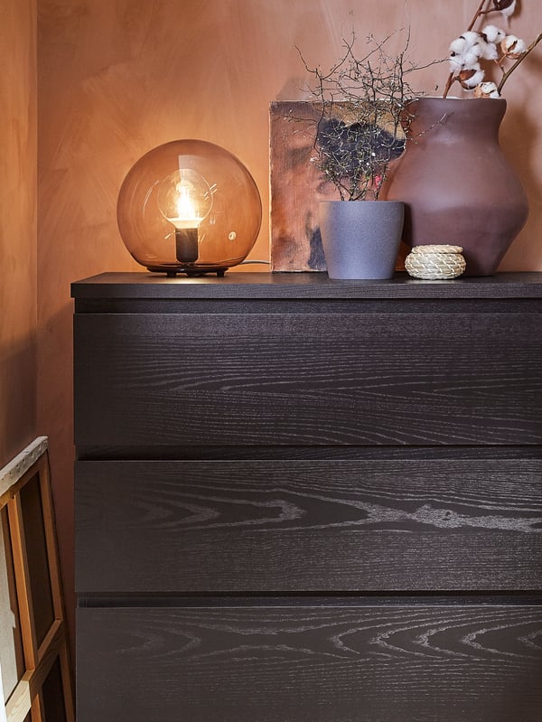 EVEDAL and FADO table lamps clustered on a cabinet, next to gold framed pictures.