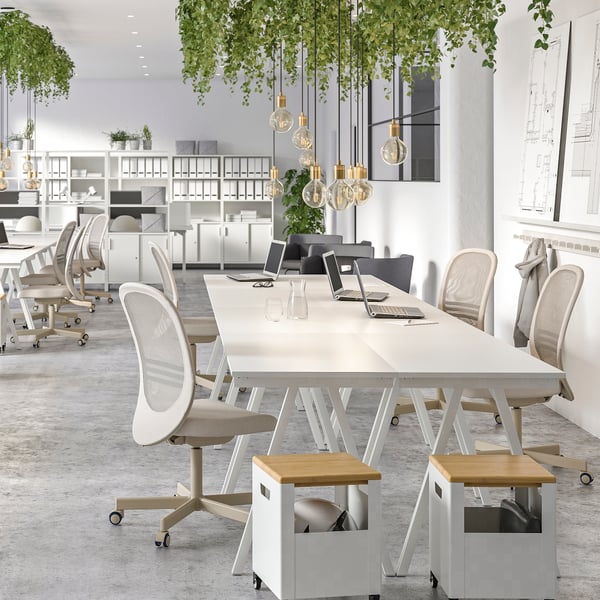 Beige-and-white TROTTEN desks placed together forming a collaboration area, surrounded by LÅNGFJÄLL office chairs.