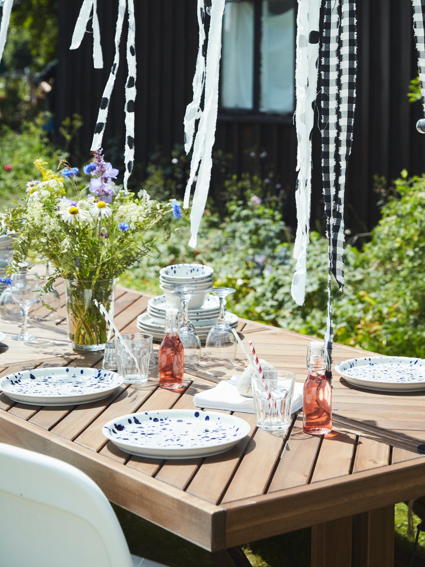 NORRMANSÖ wood table in the garden is set and decorated for a Midsummer celebration.