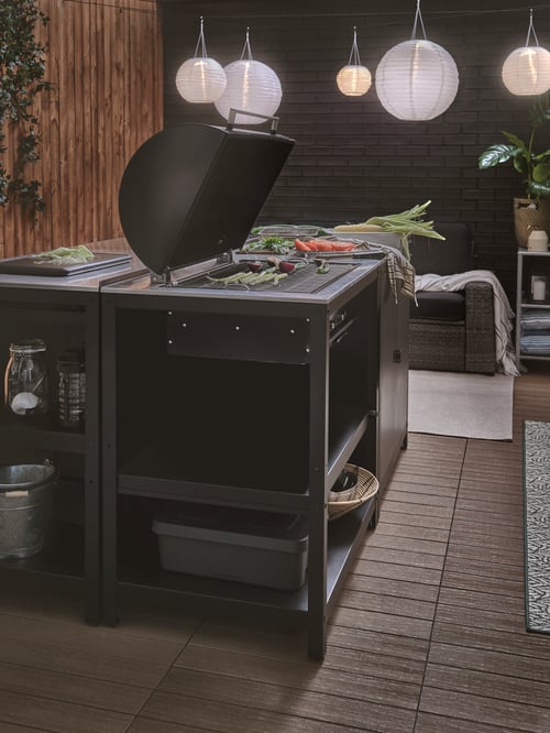 Un patio aménagé pour une soirée à l’extérieur avec un GRILLSKÄR au charbon GRILLSKÄR et des SOLVINDEN solaires à DEL SOLVINDEN .