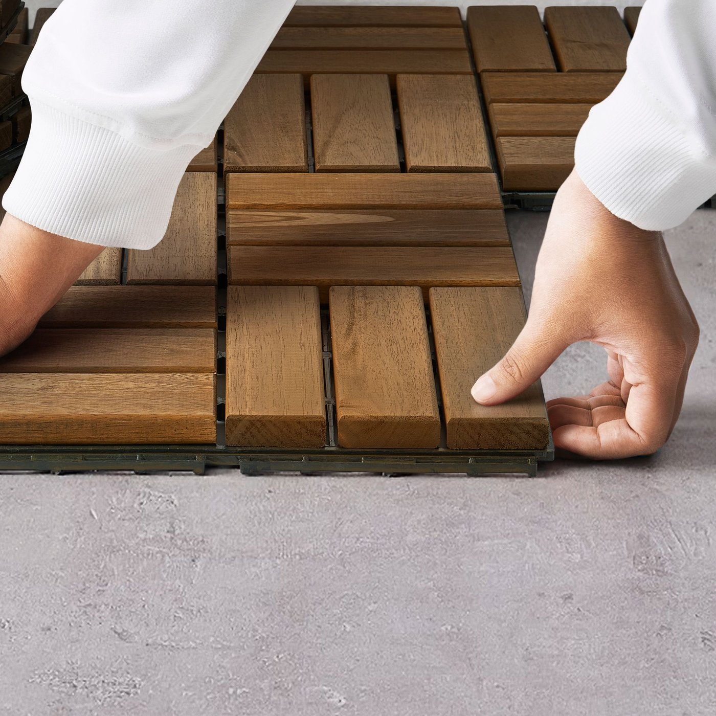 Person som håller på att lägga ett RUNNEN trallgolv i trä. 