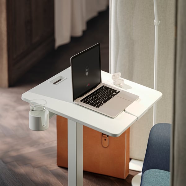 A close up of a focus corner with a white MITTZON laptop table on castors and a MITTZON acoustic screen to the side.
