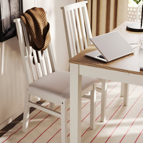 Two ÅLHULT chairs in beige with soft seats in Kabusa light beige are placed next to an beige/brown ÅLHULT extendable table.